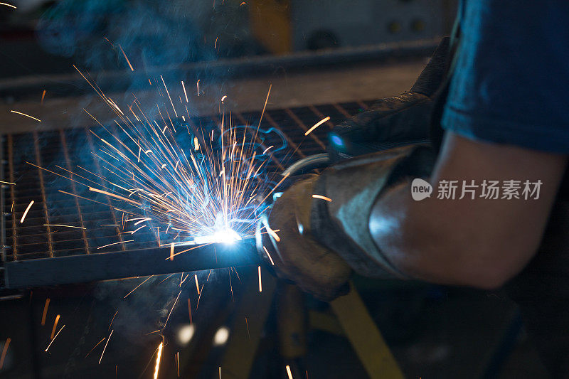 手工工人在工厂焊接金属的特写。