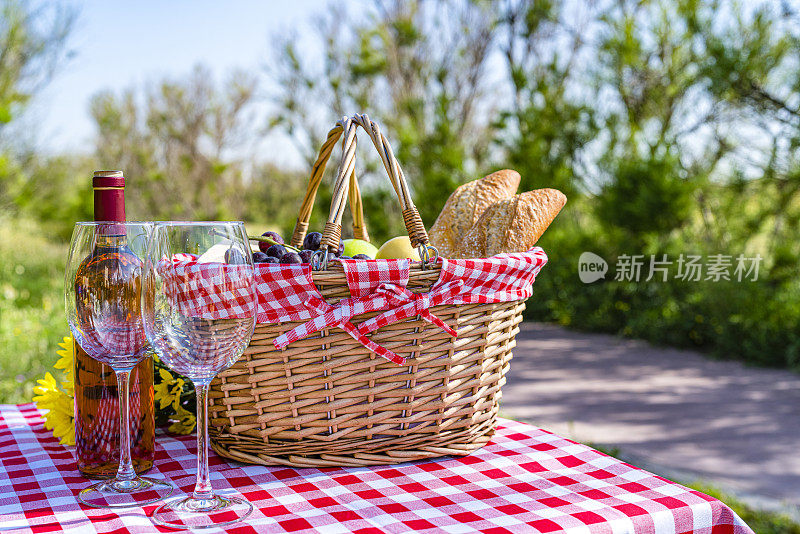 野餐篮，外面的桌子上放着食物和酒