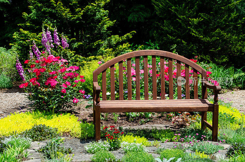 漂亮的花园小径与鲜花和花园长凳