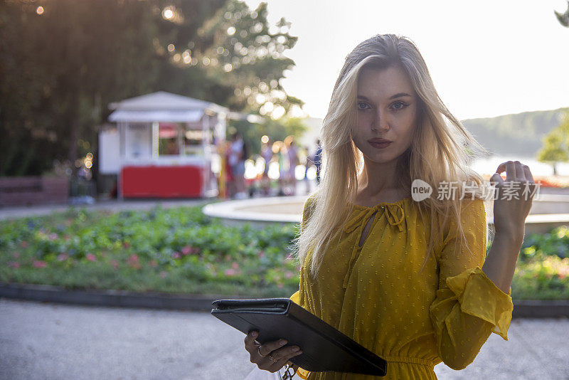 一个年轻漂亮的金发女郎正在公园里散步。