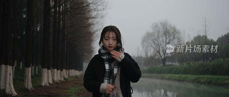 亚洲女孩走在河边的雨天