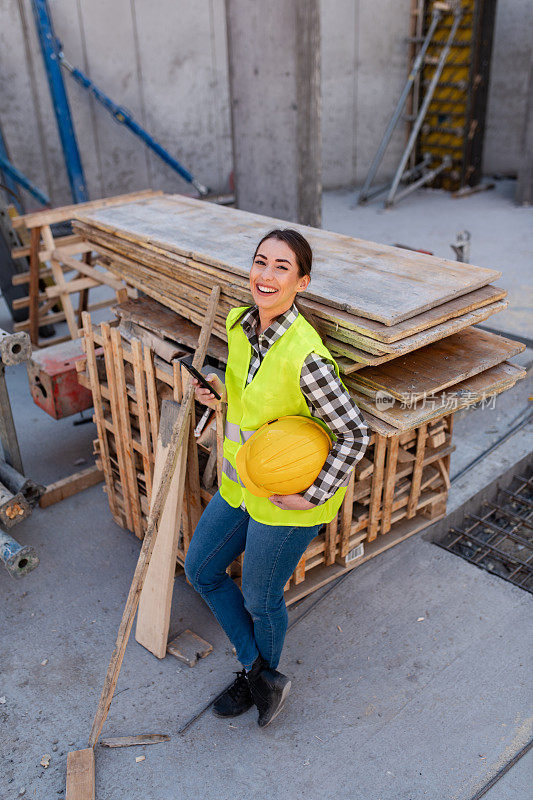 在建筑工地喝咖啡的自信的女建筑工人