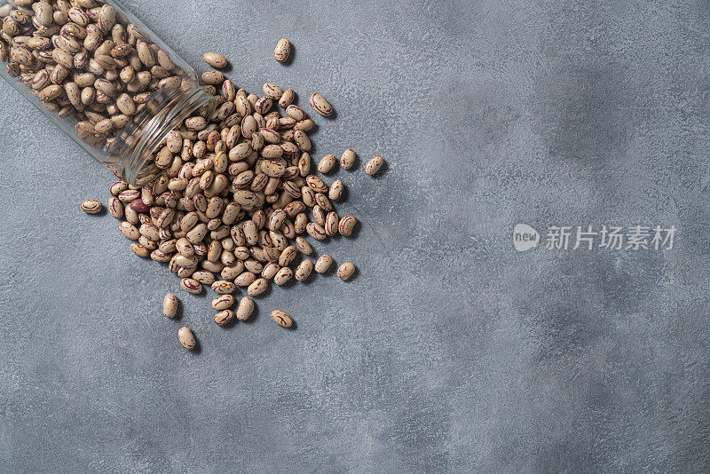 平托豆在玻璃罐上散布在灰色的石头背景拷贝空间