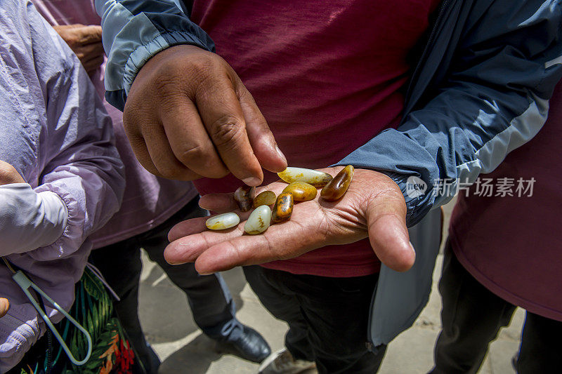 一个小贩在展示他从和田河河床上收集的玉石，中国新疆