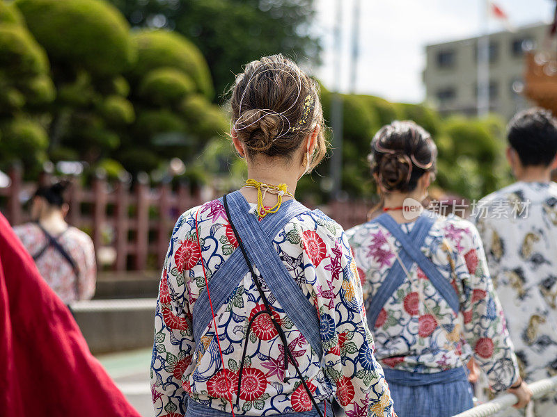 在日本传统的“祭日”上，年轻人拉着巨大的“鱼汤”花车