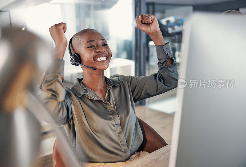 一个快乐的年轻非洲裔美国人呼叫中心电话销售代理欢呼喜悦，而在办公室工作。兴奋和雄心勃勃的女性顾问庆祝成功的销售目标和赢得胜利