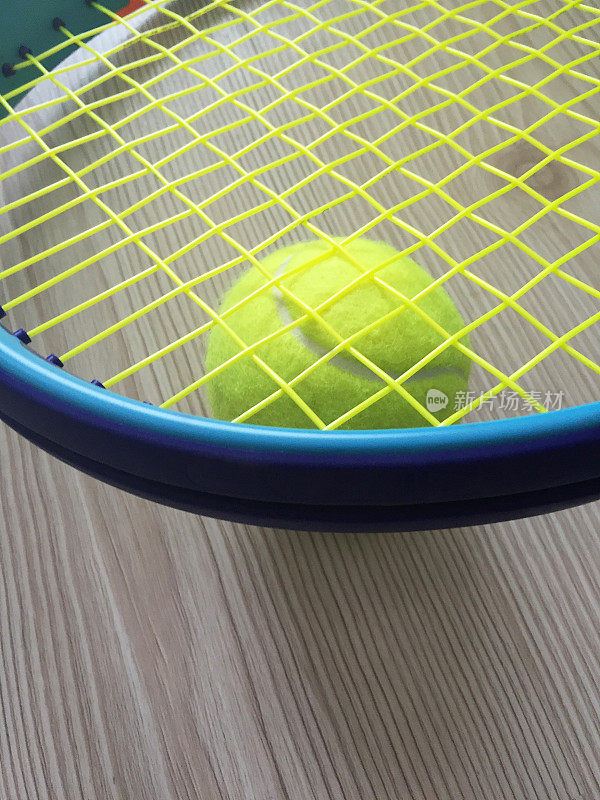 网球和网球拍，网球拍放在网球上