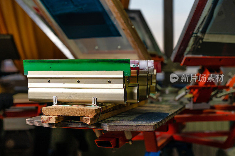绢印生产。胶刮在木架子上的印品筛分装置。在设计工作室用丝网法在t恤上印刷图像