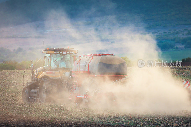 农民在拖拉机上用苗床耕作机准备土地