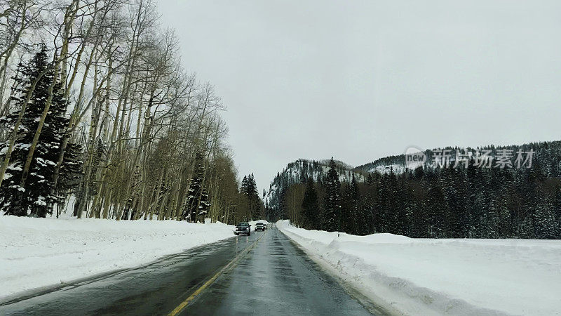 司机POV下雪的冬季山路与高雪堤在科罗拉多州西部照片系列