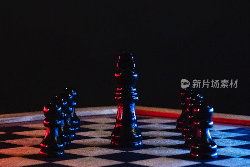 在木制棋盘上的棋子与黑色背景和蓝色和红色亮点
