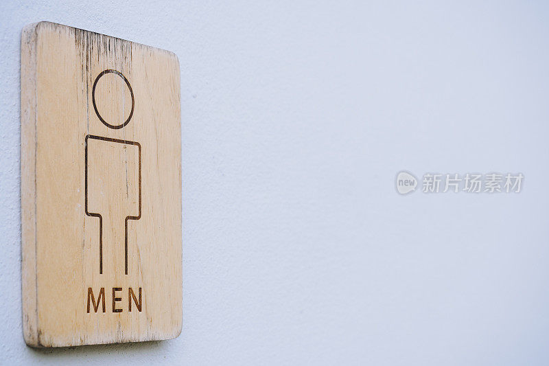 最小限度的设计男士公共厕所或厕所的标志在木板上粘贴或悬挂在白色的墙壁背景与复制空间
