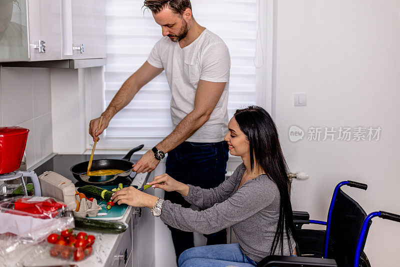 烹饪变得容易了。中年男子帮助他的残疾女友准备饭菜