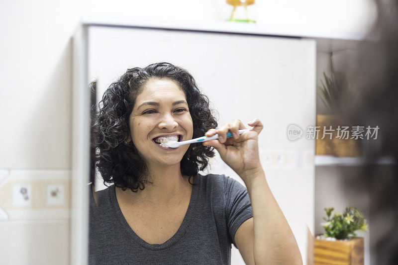 拉丁女人在浴室里愉快地刷牙