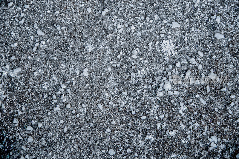 背景-向下看岩盐洒在背面表面的雪-颗粒状