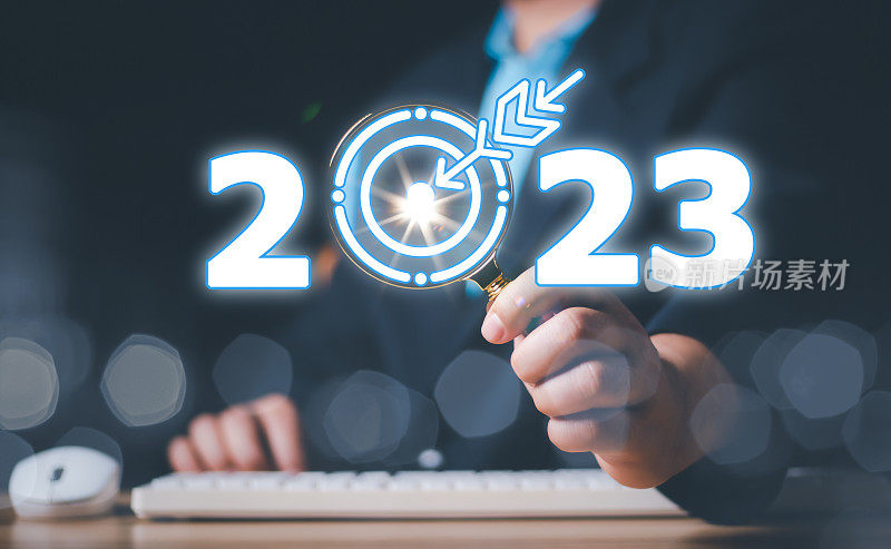 商人持有放大镜与目标符号2023黑色背景。2023概念，2023新年目标目标，行动，计划，想法，灵感概念。