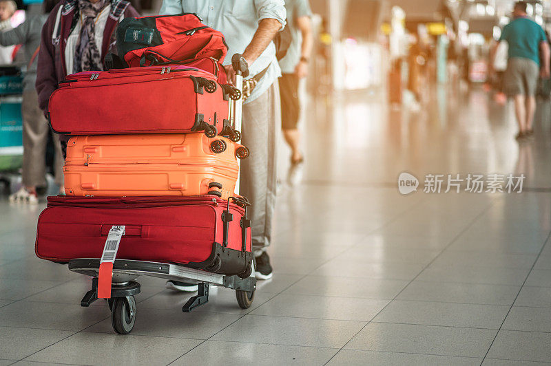 旅行者在现代化的机场航站楼拖着行李步行前往新的地方。后面的观点。副本的空间。行李，旅行者，旅行，机场，步行，度假的概念。
