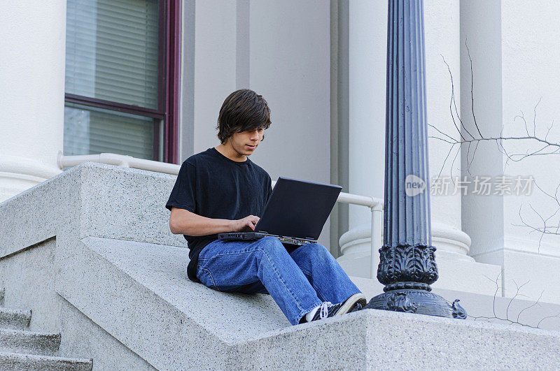 拉丁裔少年在学校台阶上学习