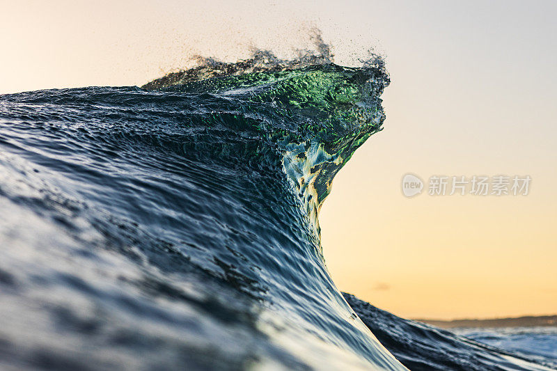 在温暖的晨光下，海浪在海洋中形成