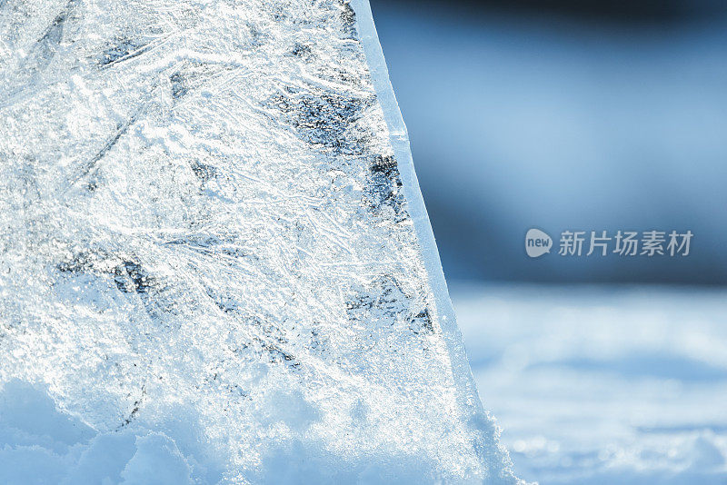 在一个阳光明媚的冬日，透明的冰碎片矗立在雪堆里