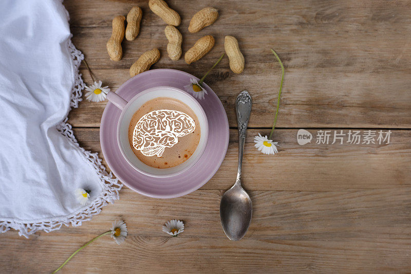 在古老的老式木桌上，用一杯喝咖啡卡布奇诺和大脑形式的泡沫，咖啡因改善人类大脑功能，刺激神经系统，健康利与弊，复制空间