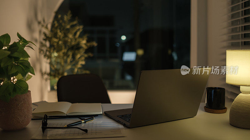 笔记本电脑，财务文件，眼镜和咖啡杯放在黑房间的白色桌子上