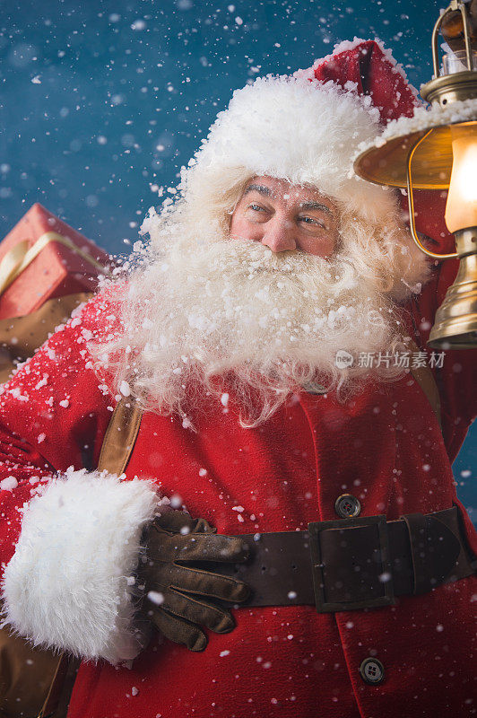 圣诞老人在户外用老式灯笼照亮道路