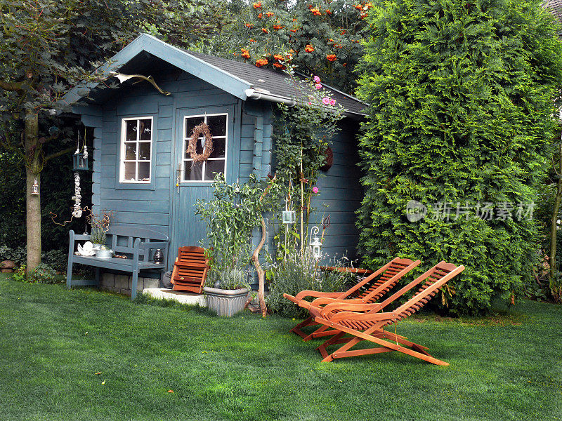蓝色花园小屋与木制躺椅