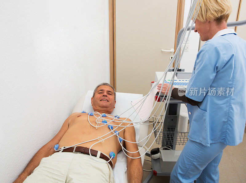 心电描记法……资深医生，护士正在记录心电图