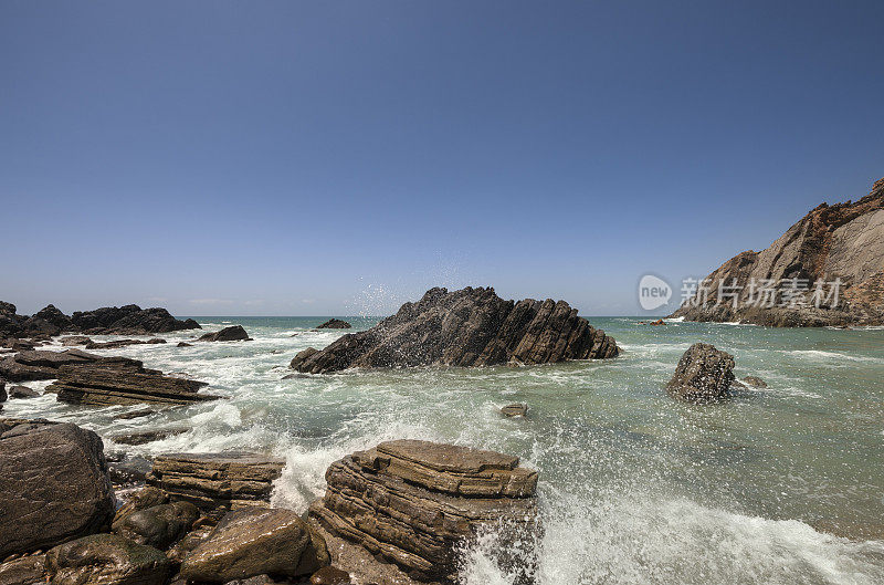 一波大西洋海浪冲入多岩石的葡萄牙海岸