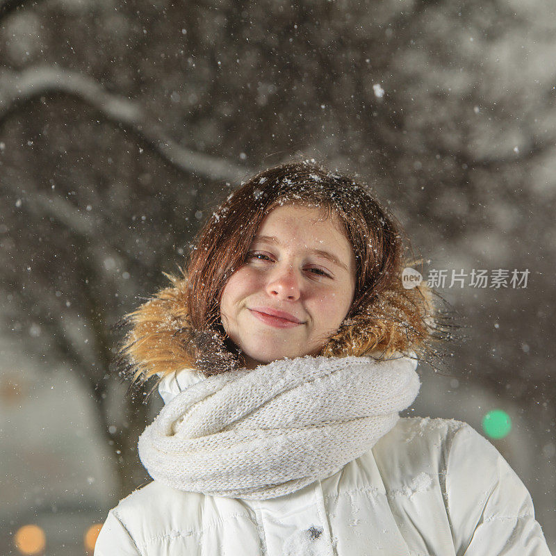 雪下穿着白色夹克的漂亮少女