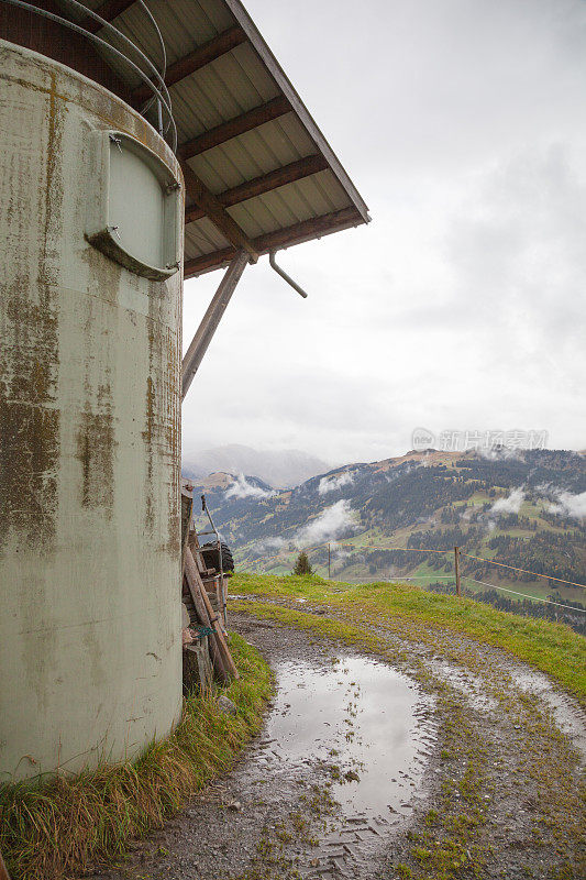 瑞士阿尔卑斯山的农场跑道和谷仓，潮湿的天气