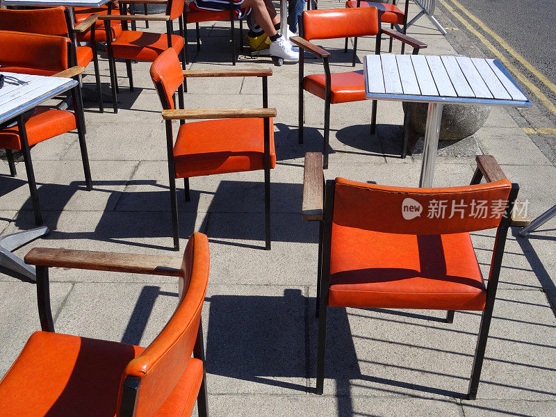 外面的咖啡桌和人行道上的橙色椅子
