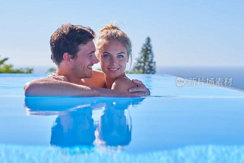 一对迷人的年轻夫妇在很棒的游泳池里放松