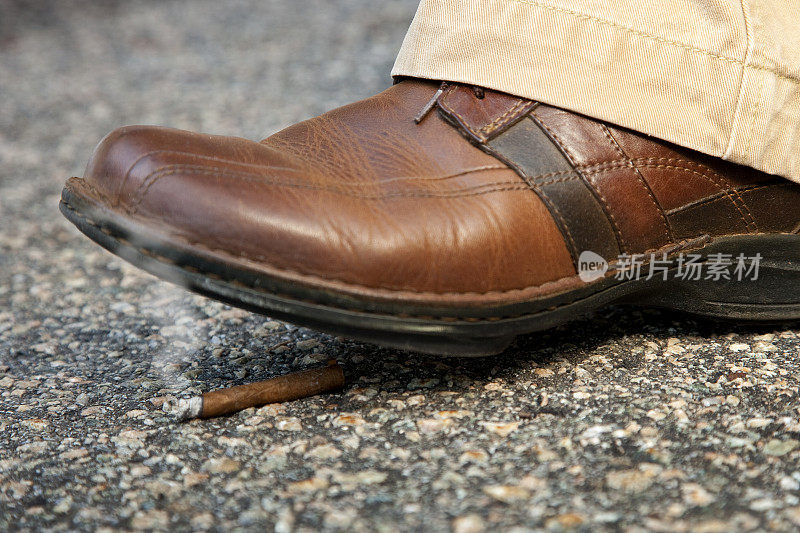 男人的鞋差点踩到一个点燃的烟头
