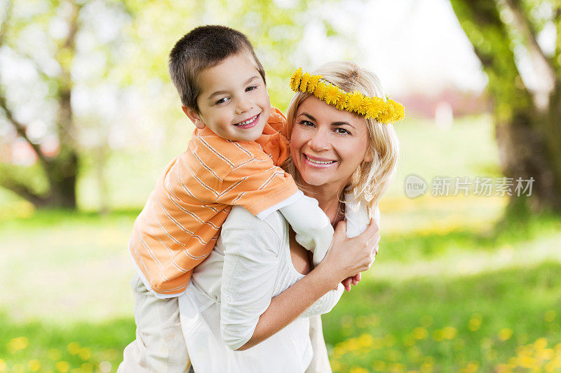 妈妈让她的儿子骑在背上。