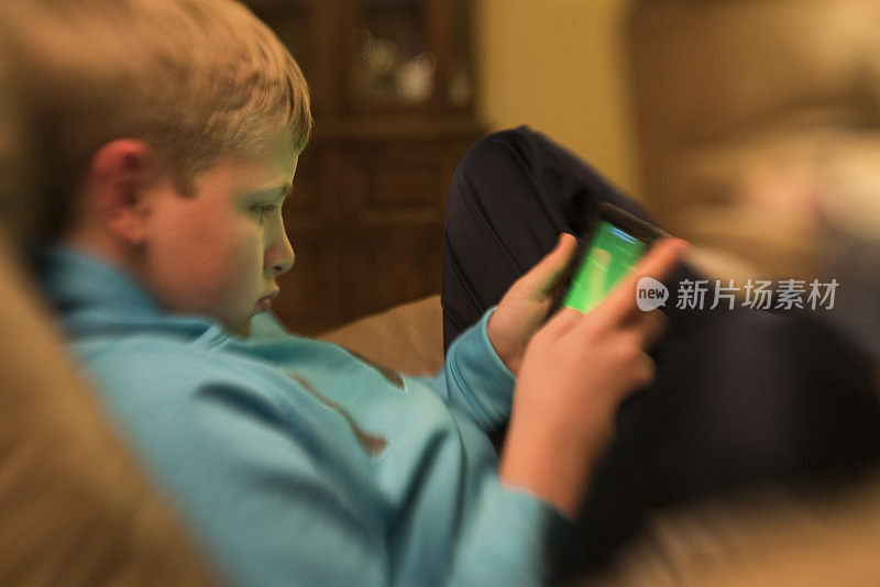 男孩在智能手机上玩游戏