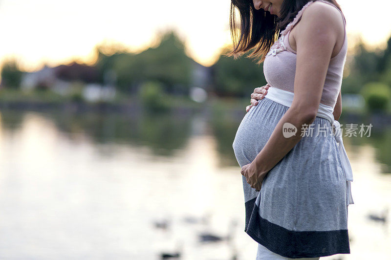 美丽的民族母亲抱着她怀孕的肚子