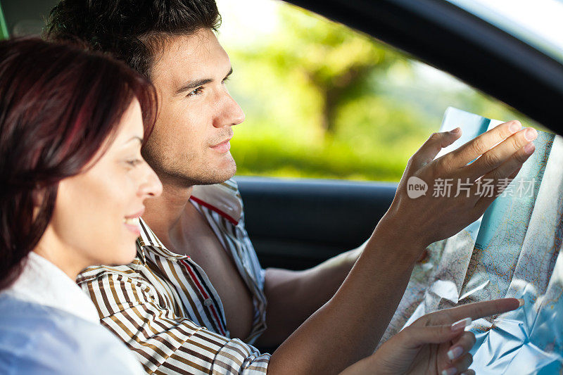 情侣在汽车中通过地图寻找方向