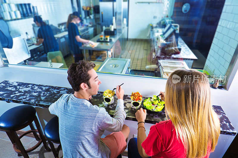 年轻夫妇在开放式厨房的休闲户外快餐店用餐