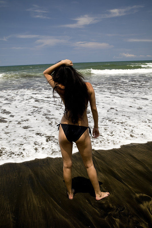 巴厘岛水明漾黑沙滩上的女孩