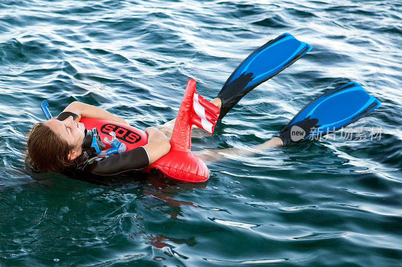 穿着潜水服的女人拿着求救浮标