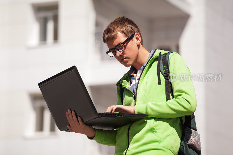 年轻人在城市街道上使用笔记本电脑