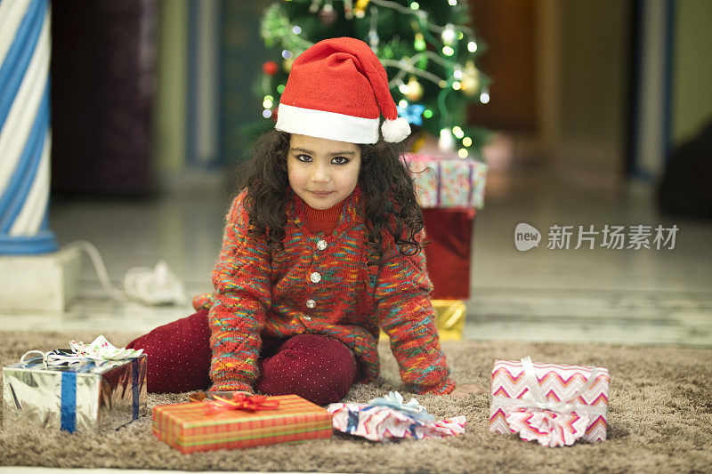 印度女孩戴着圣诞帽和圣诞礼物