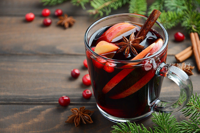 圣诞热葡萄酒与苹果和蔓越莓。用冷杉枝，蔓越莓和香料装饰的假日概念。