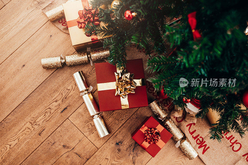 圣诞树旁放着礼盒和圣诞爆竹。