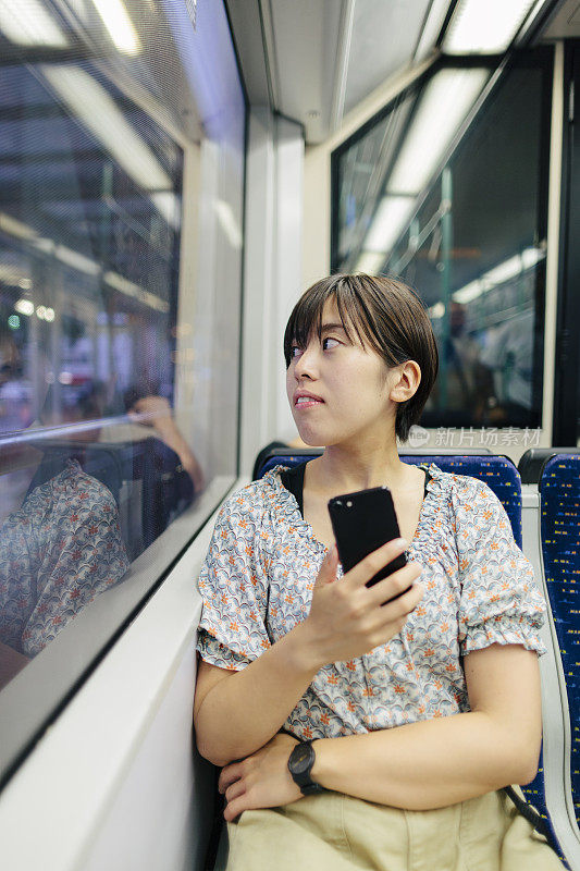 在伊斯坦布尔的公共火车上看窗外的日本女游客