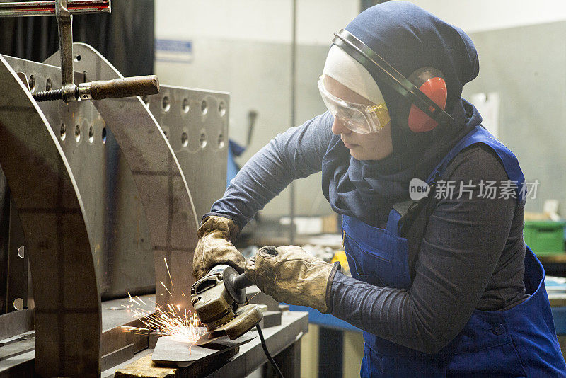 年轻的女实习生在一家金属制造公司的磨床上工作