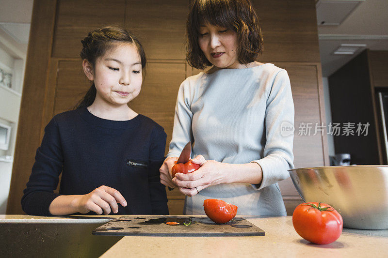 母亲和女儿切西红柿