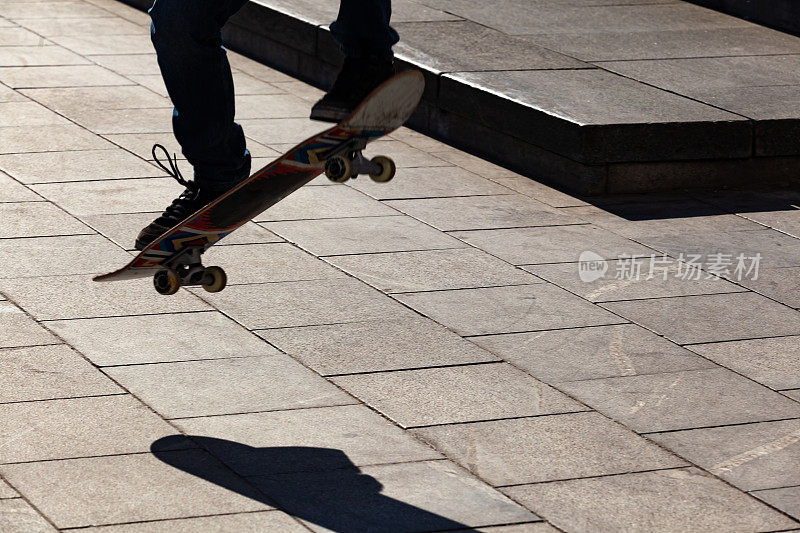 剪影的滑板谁跳在街道上的一个滑板在城市。